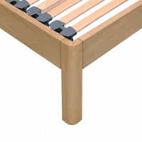 Close-up of a solid oak wooden bed frame with  slatted bed base with dark Gray slat caps.