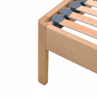 Close-up of a solid wood bed with corner detail showing radiused leg